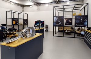 Modular trade show booth with black steel frames and wood displays for industrial exhibition